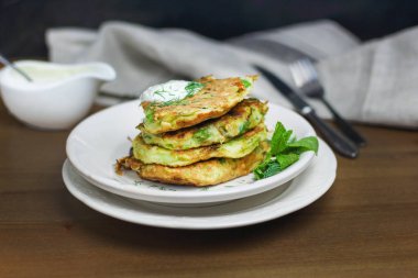 Doğru beslenme, vejetaryen kahvaltı glutensiz, fasulye ile kabak kabak krep, ekşi yunan yougurt ile beyaz tabaklarda nane, siyah arka plan, havlu, çatal, ahşap yüzeyüzerinde bıçak