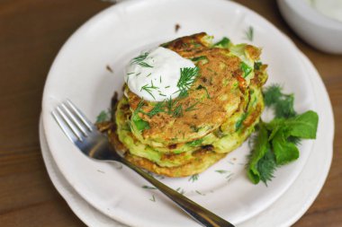 Doğru beslenme, vejetaryen kahvaltı glutensiz, fasulye ile kabak kabak krep, ekşi yunan yougurt ile beyaz tabaklarda nane, siyah arka plan, havlu, çatal, ahşap yüzeyüzerinde bıçak