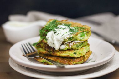 Doğru beslenme, vejetaryen kahvaltı glutensiz, fasulye ile kabak kabak krep, ekşi yunan yougurt ile beyaz tabaklarda nane, siyah arka plan, havlu, çatal, ahşap yüzeyüzerinde bıçak