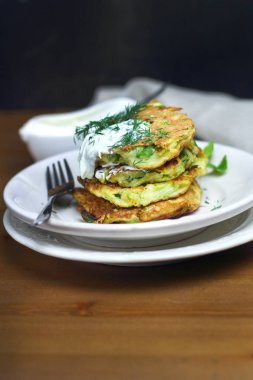 Doğru beslenme, vejetaryen kahvaltı glutensiz, fasulye ile kabak kabak krep, ekşi yunan yougurt ile beyaz tabaklarda nane, siyah arka plan, havlu, çatal, ahşap yüzeyüzerinde bıçak