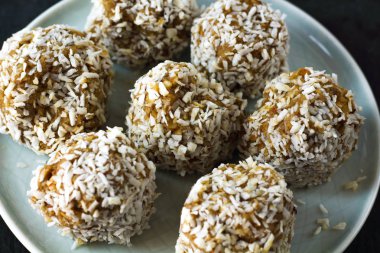 vejetaryen çiğ sağlıklı diyet hiçbir fırında şekertatlı şekersiz tatlı şekerler şeker siz ve hindistan cevizi ile glutensiz, mavi plaka ve siyah kayrak arka plan üzerinde uygun beslenme snack, metin için ücretsiz kopya alanı