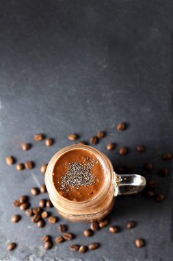 Kahve çekirdekleri ile siyah bir grafit arduvaz arka planda cam kavanoz Chia tohumları ile organik doğal çikolata kahve kakao Smoothie içecek, üst görünüm. Sağlıklı diyet vejetaryen snack. Ücretsiz kopya alanı