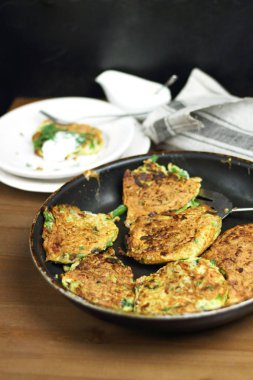 Doğru beslenme, vejetaryen kahvaltı glutensiz, fasulye ile kabak kabak krep, ekşi yunan yoğurt ile tavada nane, siyah arka plan, havlu, çatal, ahşap yüzeyüzerinde bıçak