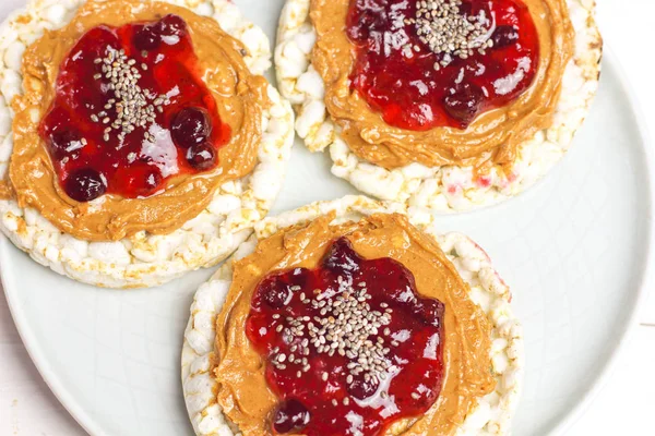 crunchy natural peanut butter strawberry jam jelly sandwich with chia seeds on rice cake bread. Proper nutrition diet vegetarian breakfast