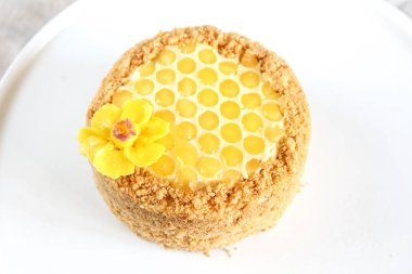 Rus katmanlı bal kek medovic tatlı beyaz ahşap tepsi üzerinde çikolata petek ve tereyağı krem şekli narcissus çiçek ile süslenmiş ahşap bal kaşığı yanında tatlı. doğum günü partisi kutlaması