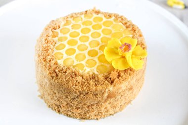 Rus katmanlı bal kek medovic tatlı beyaz ahşap tepsi üzerinde çikolata petek ve tereyağı krem şekli narcissus çiçek ile süslenmiş ahşap bal kaşığı yanında tatlı. doğum günü partisi kutlaması