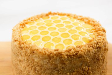 Rus katmanlı bal kek medovic tatlı beyaz ahşap tepsi üzerinde çikolata petek ve tereyağı krem şekli narcissus çiçek ile süslenmiş ahşap bal kaşığı yanında tatlı. doğum günü partisi kutlaması