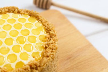 Rus katmanlı bal kek medovic tatlı beyaz ahşap tepsi üzerinde çikolata petek ve tereyağı krem şekli narcissus çiçek ile süslenmiş ahşap bal kaşığı yanında tatlı. doğum günü partisi kutlaması