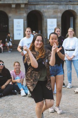 Amsterdam, Hollanda, Temmuz, 2019: Amsterdam'ın ana meydanında dans eden genç kızlar