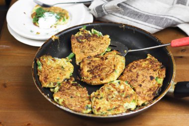 Doğru beslenme, vejetaryen kahvaltı glutensiz, fasulye ile kabak kabak krep, ekşi yunan yoğurt ile tavada nane, siyah arka plan, havlu, çatal, ahşap yüzeyüzerinde bıçak