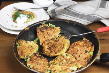 Doğru beslenme, vejetaryen kahvaltı glutensiz, fasulye ile kabak kabak krep, ekşi yunan yoğurt ile tavada nane, siyah arka plan, havlu, çatal, ahşap yüzeyüzerinde bıçak