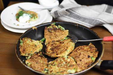 Doğru beslenme, vejetaryen kahvaltı glutensiz, fasulye ile kabak kabak krep, ekşi yunan yoğurt ile tavada nane, siyah arka plan, havlu, çatal, ahşap yüzeyüzerinde bıçak