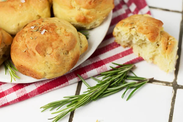 homemade fresh herb bread rolls of Provencal herbs with salt and a sprig banch of rosemary. Bread rolls bakery style on the cooling wrak