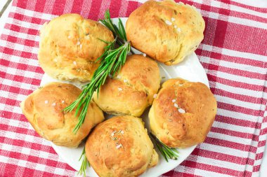 tuz ve biberiye bir sprig dalı ile Provencal otlar ev yapımı taze ot ekmek rulo. Ekmek rulo fırın tarzı beyaz tabak ve kırmızı ve beyaz havlu bir kafes İtalyan tarzı