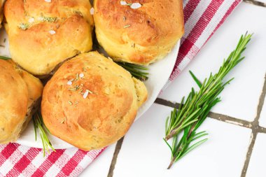 tuz ve biberiye bir sprig dalı ile Provencal otlar ev yapımı taze ot ekmek rulo. Ekmek rulo fırın tarzı beyaz tabak ve kırmızı ve beyaz havlu bir kafes İtalyan tarzı