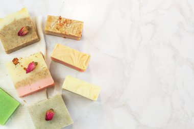 otlar ve gül tomurcukları ile el yapımı çok renkli sabun, tarak, havlu, ayna, mermer arka plan üzerinde yüz fırçası. Yüz ve vücut bakım ları için spa çevre dostu set kiti düz yatıyordu instagram tarzı