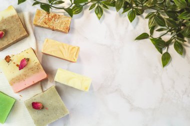 otlar ve gül tomurcukları ile el yapımı çok renkli sabun, tarak, havlu, ayna, mermer arka plan üzerinde yüz fırçası. Yüz ve vücut bakım ları için spa çevre dostu set kiti düz yatıyordu instagram tarzı