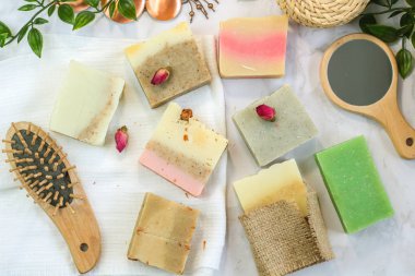 otlar ve gül tomurcukları ile el yapımı çok renkli sabun, tarak, havlu, ayna, mermer arka plan üzerinde yüz fırçası. Yüz ve vücut bakım ları için spa çevre dostu set kiti düz yatıyordu instagram tarzı