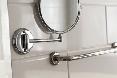 Otel spa evinin duvarında asılı duran yuvarlak büyüteç aynası beyaz fayansların üzerinde. Banyo lüks iç mekan.. 