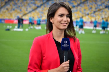 Kiev, Ukrayna - 26 Mayıs 2018: önce 2018 Uefa Şampiyonlar Ligi final maçı, Ukrayna çok güzel bir kız bir gazeteci bir mikrofon ile bir röportaj hazırlanıyor