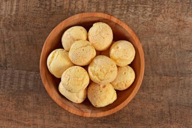 Ahşap arka plan üzerinde peynir ekmek rustik kase