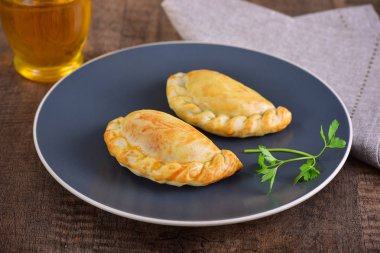 Ahşap arka planda et kavrulmuş empanas