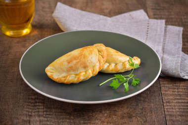 Ahşap arka planda et kavrulmuş empanas