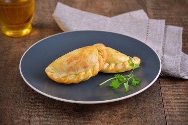 Ahşap arka planda et kavrulmuş empanas