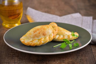 Ahşap arka planda et kavrulmuş empanas