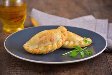 Ahşap arka planda et kavrulmuş empanas