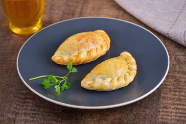 Ahşap arka planda et kavrulmuş empanas