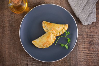 Ahşap arka planda et kavrulmuş empanas