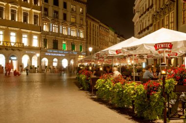 Krakow, Polonya - 25 Eylül: 25 Eylül 2007 tarihinde zevk restoranlar ve mağazalar Krakow ana meydanında insanlar. Krakow's Market Square Avrupa'nın en büyük Ortaçağ Pazar Meydanı olduğunu