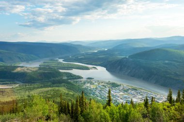 Dawson şehri ve Yukon nehrinin panoramik manzarası. Kanada 'nın Yukon bölgesindeki Midnight Dome dağının tepesinden.