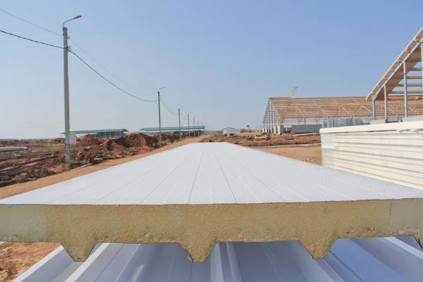 Sandwich panels at the construction site. Material for warming the walls of the building. Technologies in construction. An alternative to a brick building.