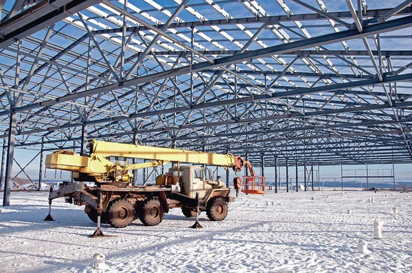 Automobile crane on the background of a metal frame under construction
