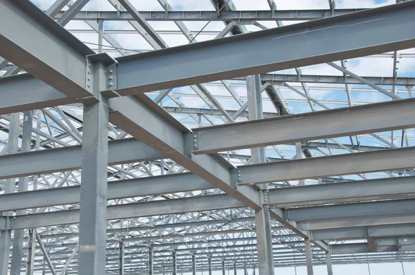 Metal frame of the new building against the blue sky with clouds