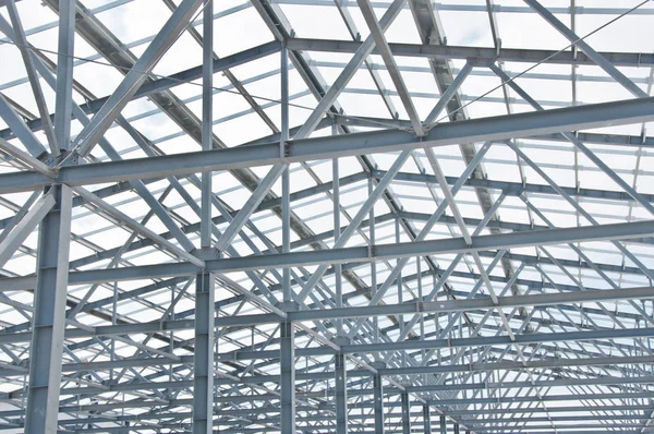 Metal frame of the new building against the blue sky with clouds