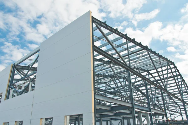 Metal frame of the building with a sandwich panel of insulation on the wall. Construction of a new industrial building. — Stock Image Metal Frame Building Sandwich Panel Insulation Wall Construction New Industrial Stock Photo