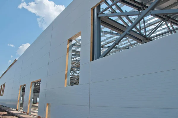 Thermal insulation of the metal frame of the building with insulation panels. The process of installing insulation panels. Modern building insulation.