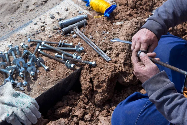 The hands of the worker tighten the bolts and nuts. Preparation for installation work. The working process.