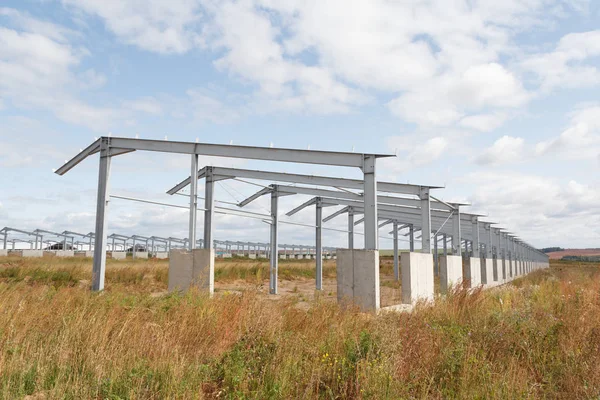 Construction of agricultural buildings. The frame of the roof of the new barn for cows. Construction of a new barn. Wooden beams on a metal frame.