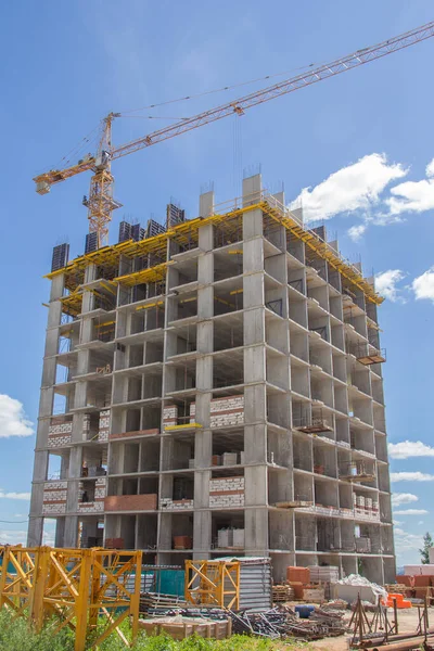 Construction at the background of blue sky. Residential building. Reinforced concrete frame of the building.