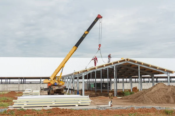 Metal frame of the building with a sandwich panel of insulation on the wall. Construction of a new industrial building. Modern Insulation of the walls of the building panels of insulation.