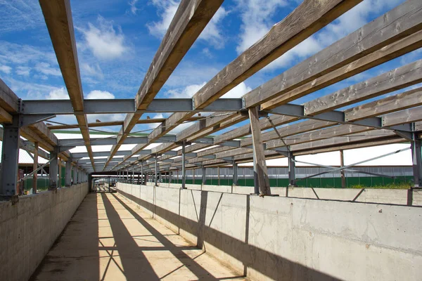 The roof design. Wooden beams on a steel frame. Steel frame of a building under construction.