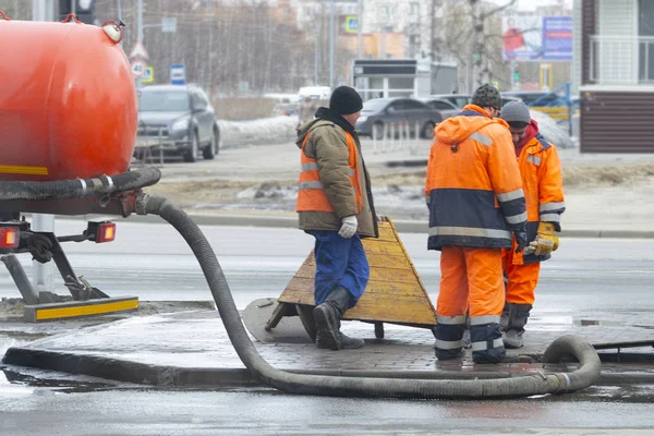 Pracownicy Wypompowali Ścieki Pobliżu Drogi Przez Właz Pomocą Dwóch Wyspecjalizowanych — Zdjęcie stockowe