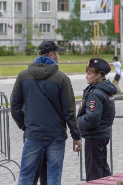 Polis kız erkeklerle sokakta konuşuyor, Surgut, Rusya - 12 Haziran 2019