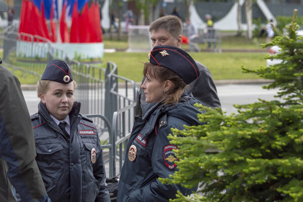 Two police girls talking on the street with men, Surgut, Russia - June 12, 2019