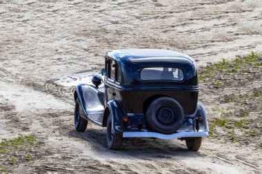Retro araba kum üzerinde siyah sürmek. Arkadan üstten görünüm, Surgut, Rusya - 20 Haziran 2019