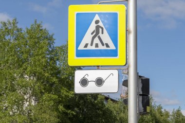 Siyah gözlük şeklinde kör yayalar için bir rozet ile mavi yol işareti ayarlanabilir yaya geçidi. Şehrin sokağı. Alt görünüm ön